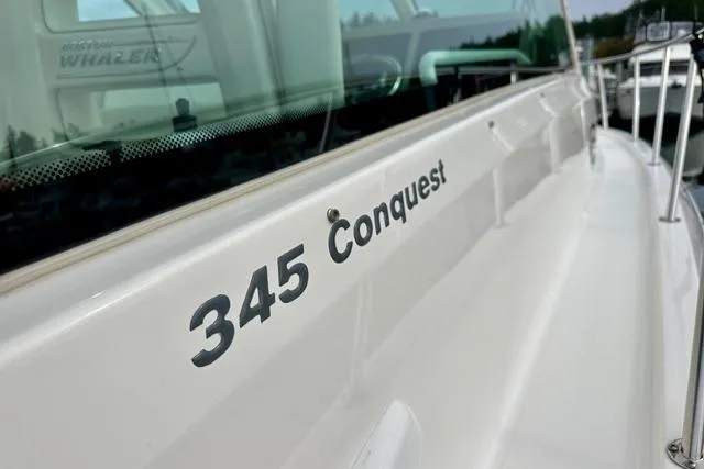  Yacht Photos Pics 2021 Boston Whaler 345 Conquest Pilothouse boat, side view with model name visible.