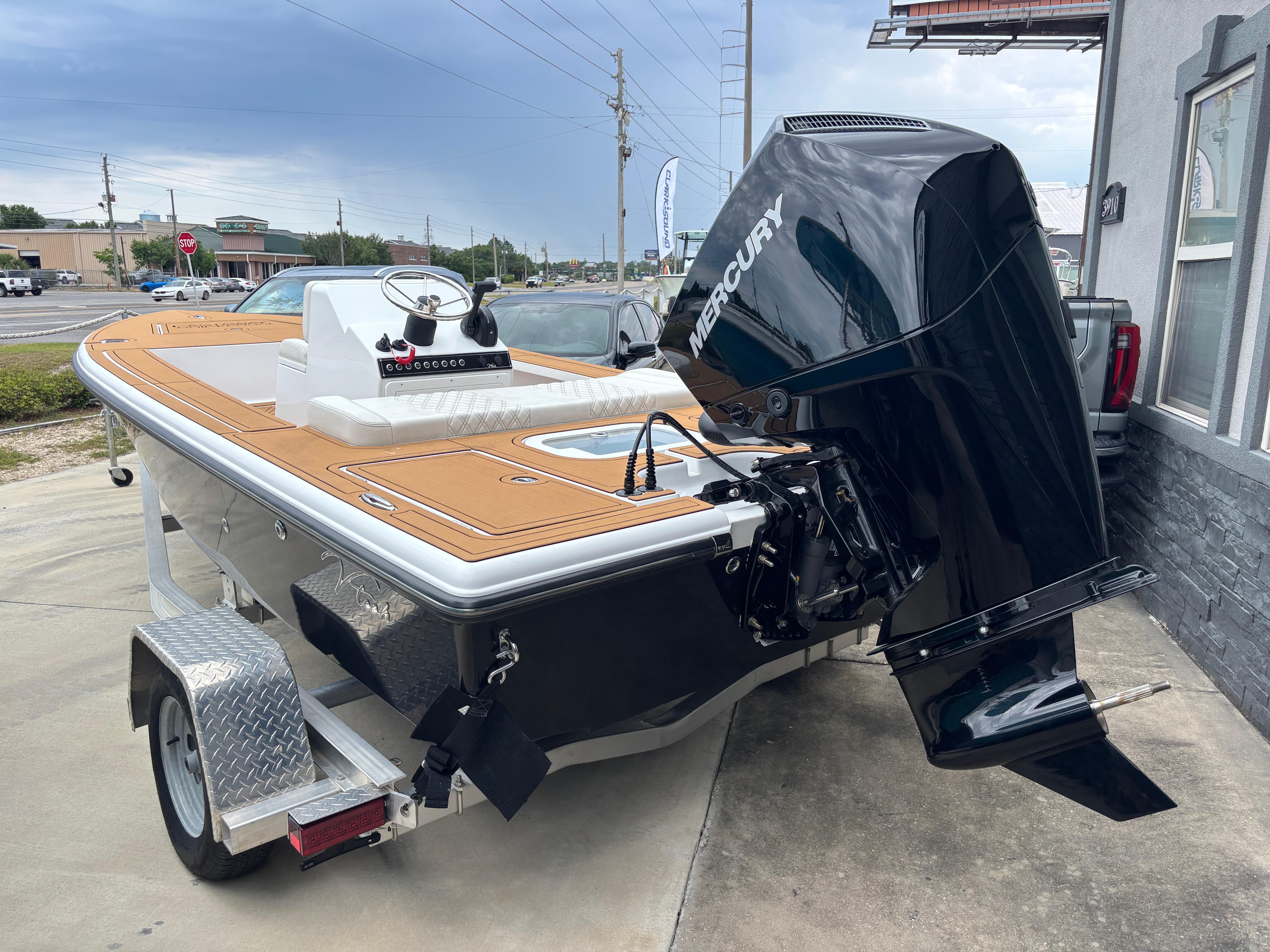 2024 Vtech 18 FLATS boat with Mercury engine on trailer, parked outdoors.