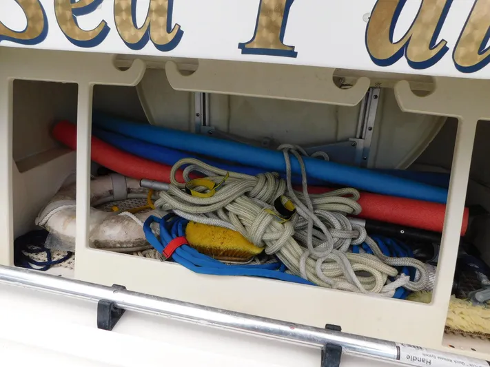 Sea Y'all Yacht Photos Pics Storage compartment on a 2004 Regal Commodore 3860 boat with ropes and pool noodles.