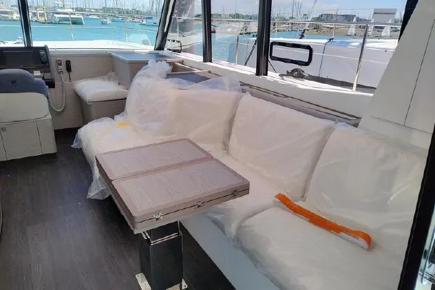  Yacht Photos Pics 2025 Fountaine Pajot MY4.S yacht interior with white seating and a foldable table.