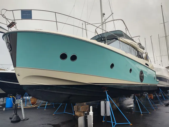 Blue Yacht Photos Pics 2019 Monte Carlo MC5 yacht on stands, turquoise hull, marina setting.