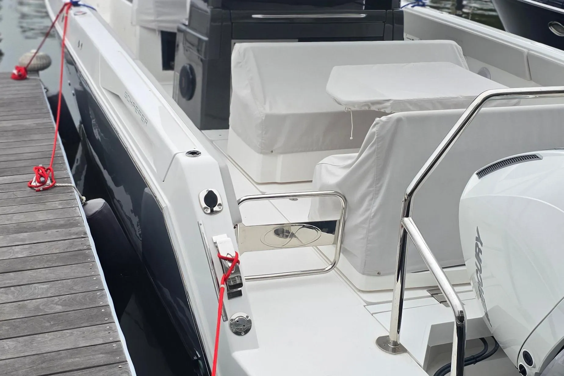 2025 Schaefer V33 boat docked, featuring sleek design and modern seating area.