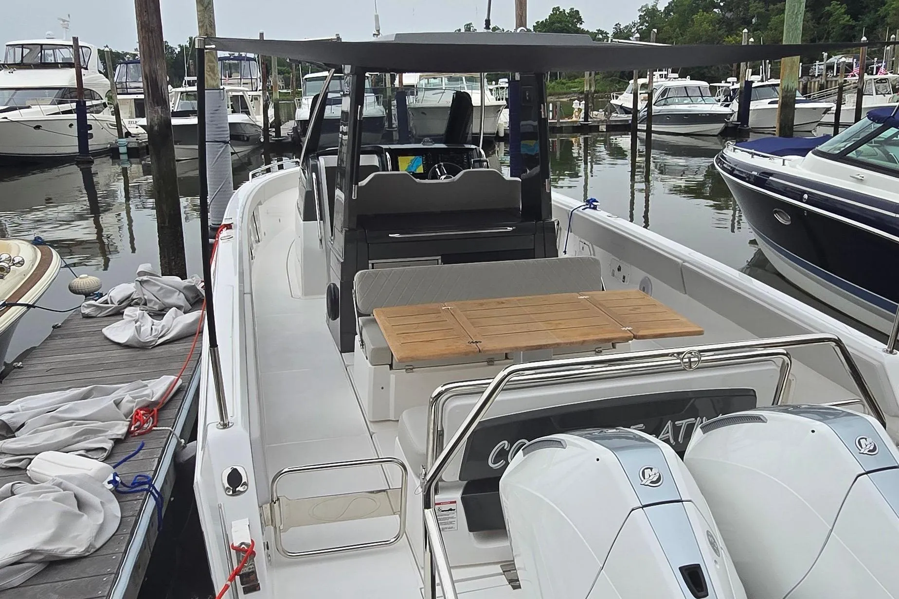 2025 Schaefer V33 boat docked, featuring sleek design and spacious seating area.