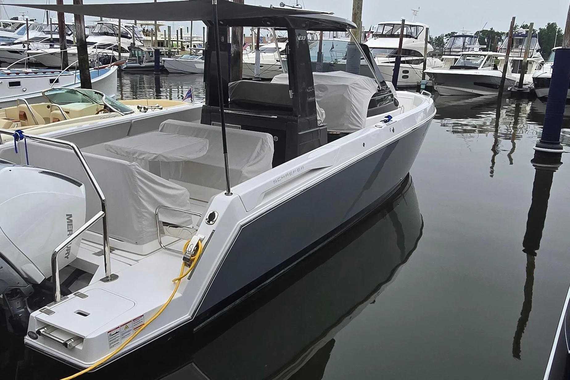 2025 Schaefer V33 boat docked in marina, featuring sleek design and modern amenities.