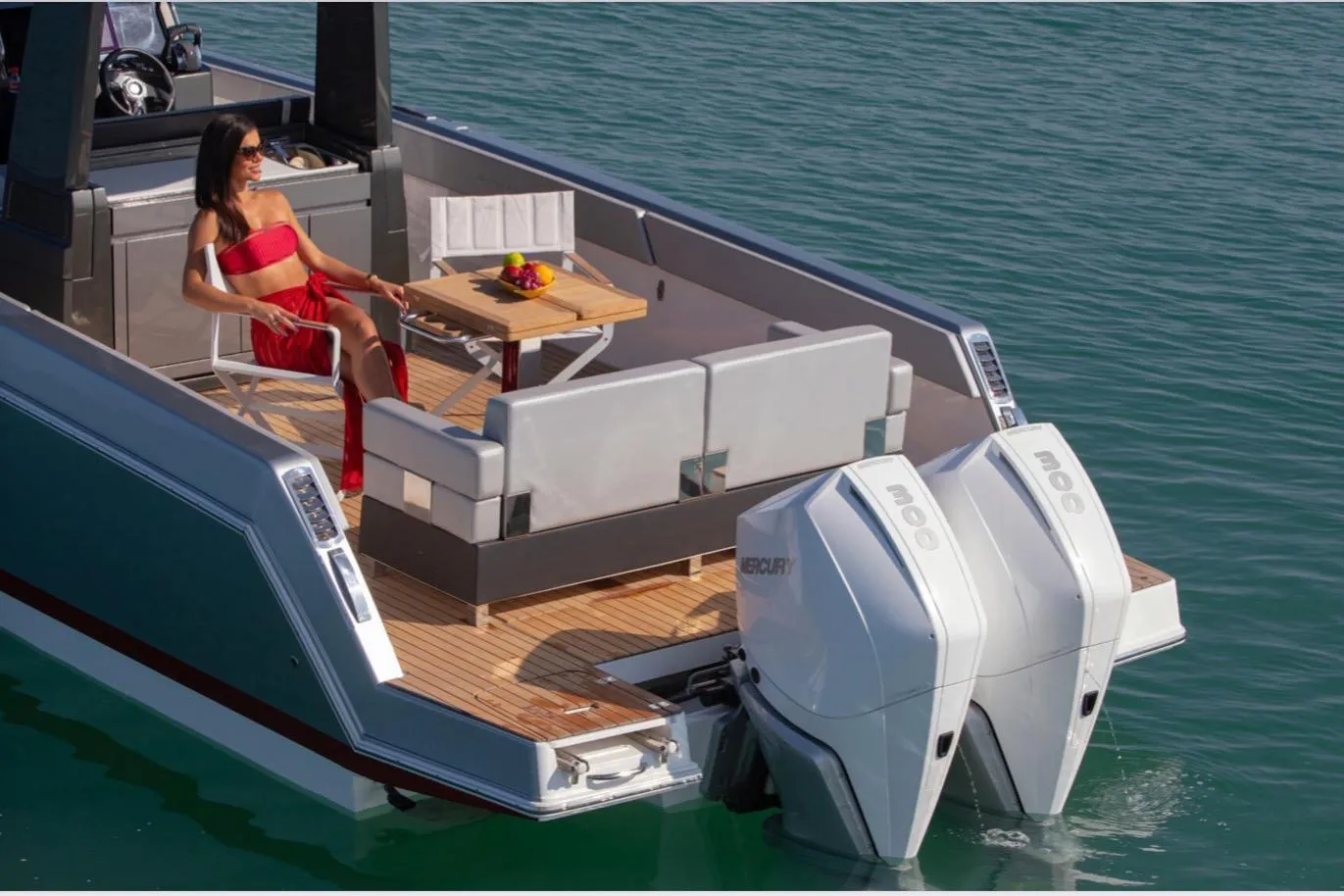 2025 Schaefer V33 yacht with woman relaxing, featuring twin Mercury outboard engines.