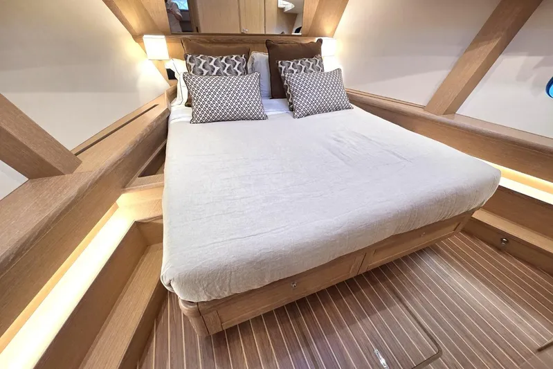 Menorquin 48 Fly Yacht Photos Pics Luxurious cabin interior of 2026 Sasga Yachts Menorquin 48 with elegant bedding and wood finish.