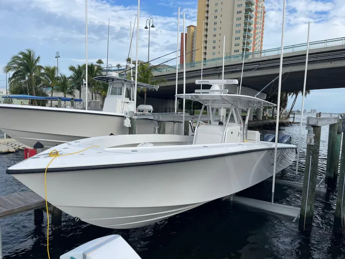 Last Resort Yacht Photos Pics 2013 Bahama Open Fisherman boat docked near a bridge, with palm trees in the background.