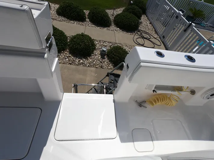  Yacht Photos Pics 2019 Invincible 39 CC boat deck with seating and hose, near landscaped garden.