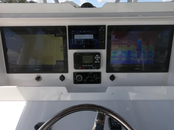  Yacht Photos Pics Control panel of 2019 Invincible 39 CC boat with navigation screens and steering wheel.