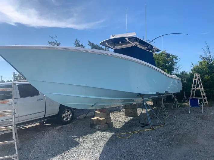  Yacht Photos Pics 2019 Invincible 39 CC boat on blocks, parked outdoors under clear sky.