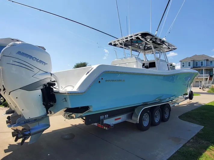  Yacht Photos Pics 2019 Invincible 39 CC boat with Mercury engine on a trailer in a driveway.