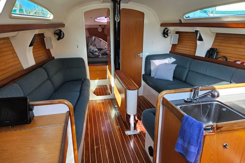 Ace Yacht Photos Pics Interior of a 2001 Farr 395 sailboat with cozy seating and wooden finishes.