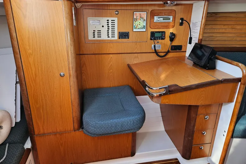 Ace Yacht Photos Pics Interior of a 2001 Farr 395 sailboat with navigation station and wooden cabinetry.