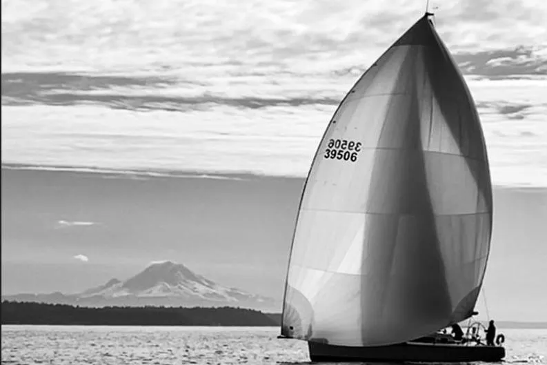 Ace Yacht Photos Pics Sailboat Farr 395 (2001) with spinnaker, mountain backdrop, and cloudy sky.
