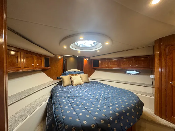  Yacht Photos Pics Luxurious 2003 Cruisers Yachts 540 Express cabin with elegant wood finish and cozy bedding.