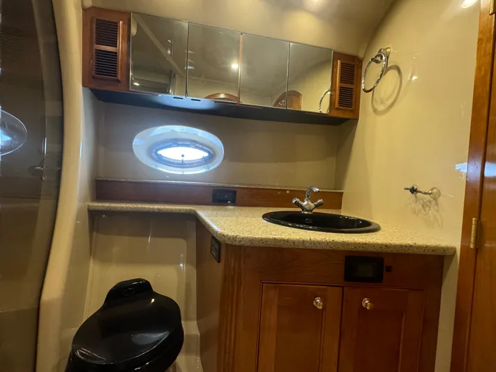  Yacht Photos Pics Luxurious 2003 Cruisers Yachts 540 Express bathroom with modern fixtures and porthole window.