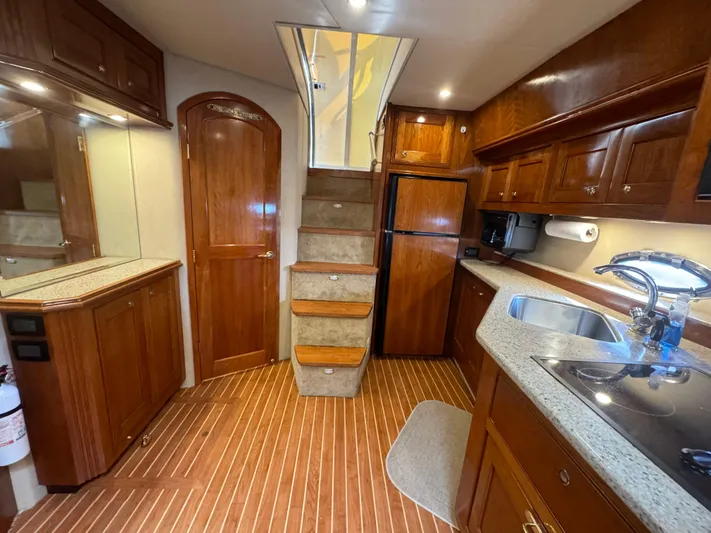  Yacht Photos Pics Luxurious 2003 Cruisers Yachts 540 Express interior with wooden cabinetry and modern kitchen amenities.