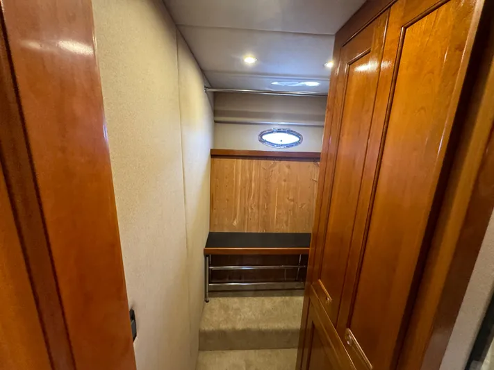  Yacht Photos Pics 2003 Cruisers Yachts 540 Express interior hallway with wooden cabinetry and porthole window.