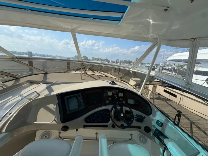  Yacht Photos Pics 2003 Cruisers Yachts 540 Express helm with navigation controls, docked at marina under clear skies.