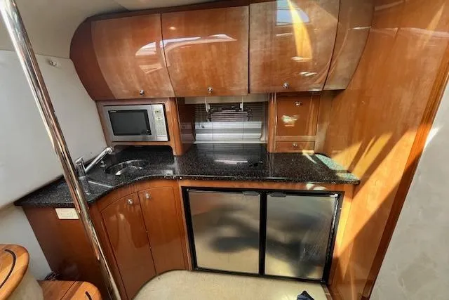  Yacht Photos Pics 2008 Doral Medditerra yacht kitchen with wood cabinets, microwave, and mini-fridge.
