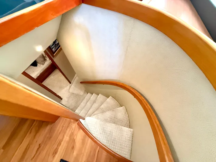  Yacht Photos Pics Curved staircase inside 2001 West Bay Sonship 58 Pilothouse yacht with wooden handrail.