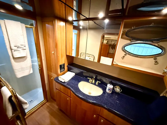  Yacht Photos Pics Luxurious bathroom in 2001 West Bay Sonship 58 Pilothouse yacht with wood cabinetry and porthole window.