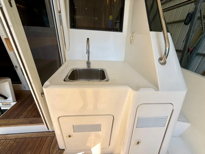  Yacht Photos Pics 2001 West Bay Sonship 58 Pilothouse yacht sink area with stainless steel faucet and storage compartments.