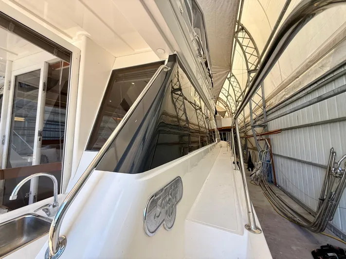  Yacht Photos Pics 2001 West Bay Sonship 58 Pilothouse yacht in covered storage, showcasing sleek design and polished railings.