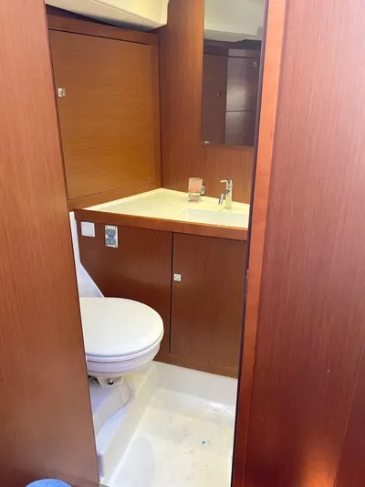  Yacht Photos Pics 2014 Beneteau Oceanis 45 bathroom with wooden cabinetry and modern fixtures.