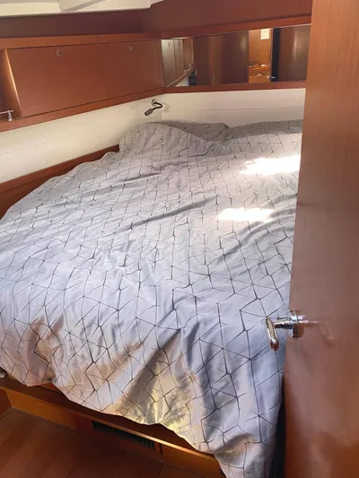  Yacht Photos Pics 2014 Beneteau Oceanis 45 cabin with cozy bed and wooden interior.