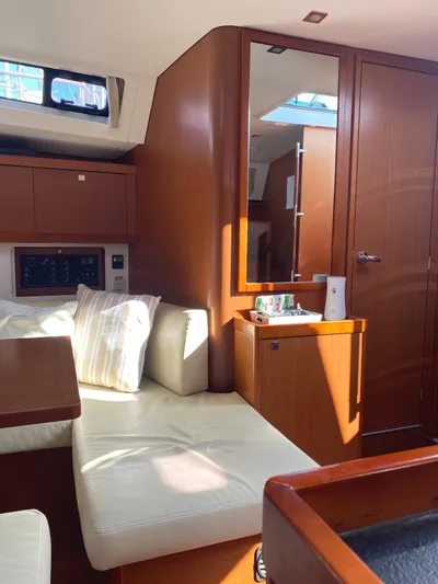  Yacht Photos Pics Interior of 2014 Beneteau Oceanis 45 yacht with cozy seating and wooden cabinetry.
