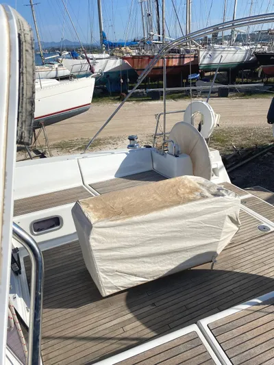  Yacht Photos Pics 2014 Beneteau Oceanis 45 yacht deck with covered equipment, docked in a marina.