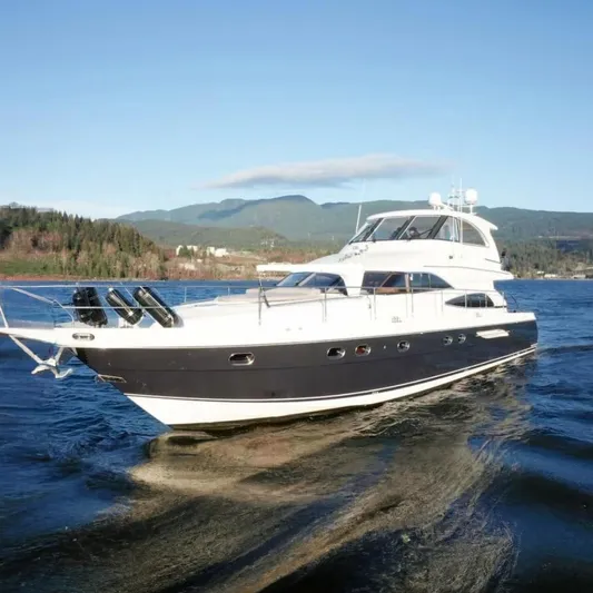 Jugni Yacht Photos Pics Luxury 2003 Viking Princess 65 yacht cruising on scenic waters with mountainous backdrop.