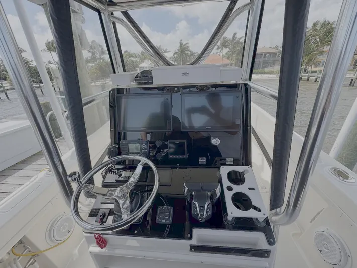  Yacht Photos Pics 2004 Intrepid 32 Cuddy boat helm with steering wheel and navigation controls.