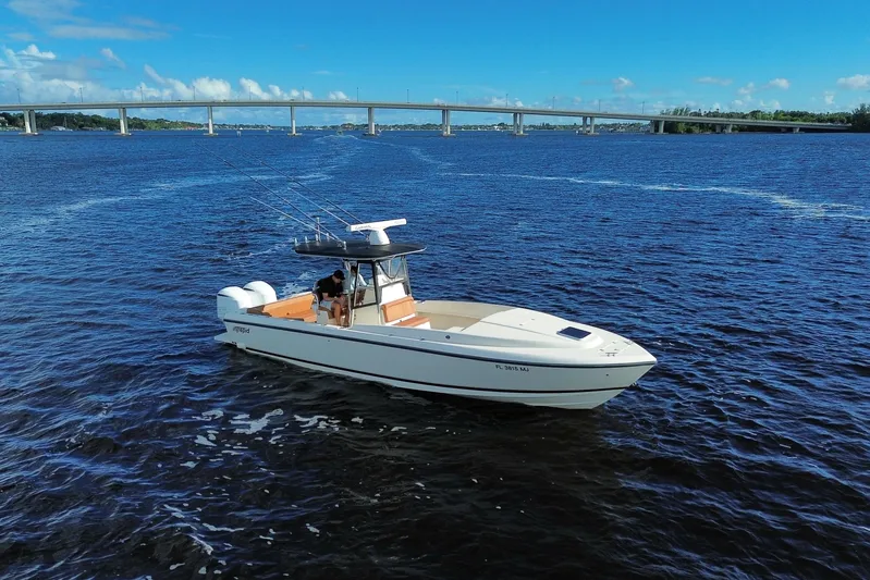  Yacht Photos Pics 2004 Intrepid 32 Cuddy boat on open water with bridge in background.