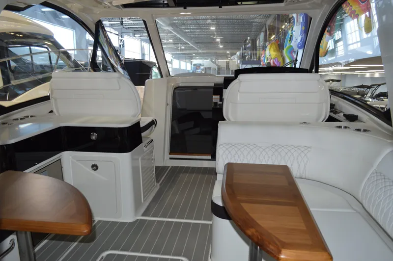  Yacht Photos Pics 2023 Sea Ray DAO 370 yacht interior with white seating and wooden tables.