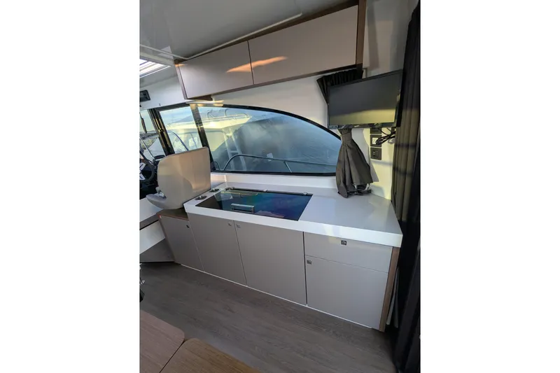  Yacht Photos Pics 2024 Beneteau Antares 11 interior with modern kitchenette and sleek cabinetry.