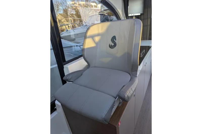  Yacht Photos Pics Gray captain's chair on 2024 Beneteau Antares 11 boat, featuring a seahorse logo.