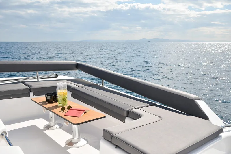  Yacht Photos Pics Luxurious seating area on 2020 Dufour Catamarans 48, overlooking serene ocean waters.