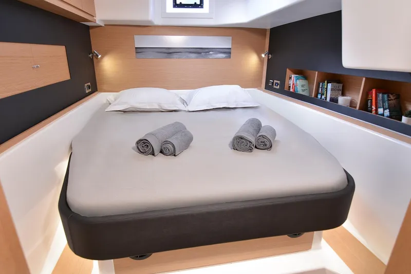  Yacht Photos Pics Luxurious cabin interior of 2020 Dufour Catamarans 48 with cozy bed and bookshelves.