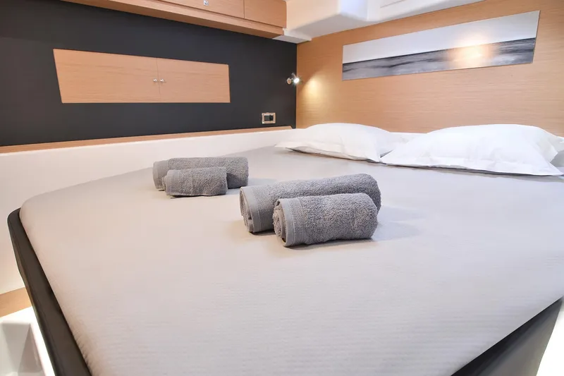  Yacht Photos Pics Luxurious bedroom interior of 2020 Dufour Catamarans 48 with neatly arranged towels.