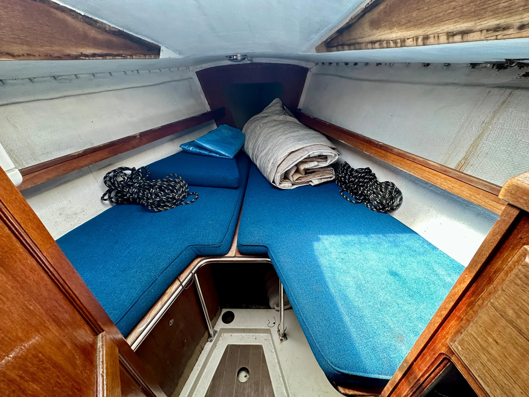 Interior of a 1982 Schock NY 36 yacht with blue cushions.
