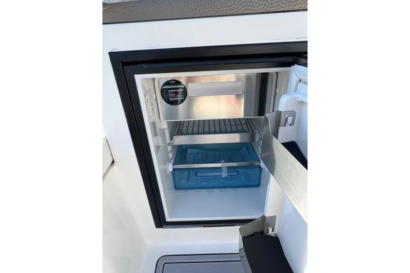  Yacht Photos Pics Open mini fridge on 2019 Sea Ray SDX 290 Outboard boat, showing interior shelves.