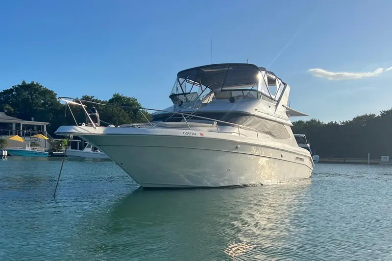  Yacht Photos Pics 1999 Sea Ray 440 Express Bridge yacht anchored in serene waters.