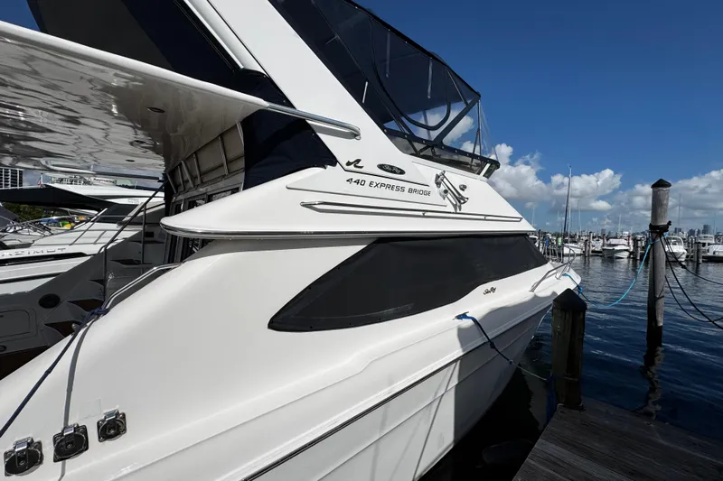  Yacht Photos Pics 1999 Sea Ray 440 Express Bridge yacht docked at marina under clear blue sky.