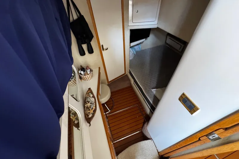  Yacht Photos Pics 1999 Sea Ray 440 Express Bridge cabin interior with bed, storage, and wooden flooring.