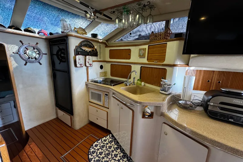  Yacht Photos Pics Interior of 1999 Sea Ray 440 Express Bridge yacht with kitchen and nautical decor.