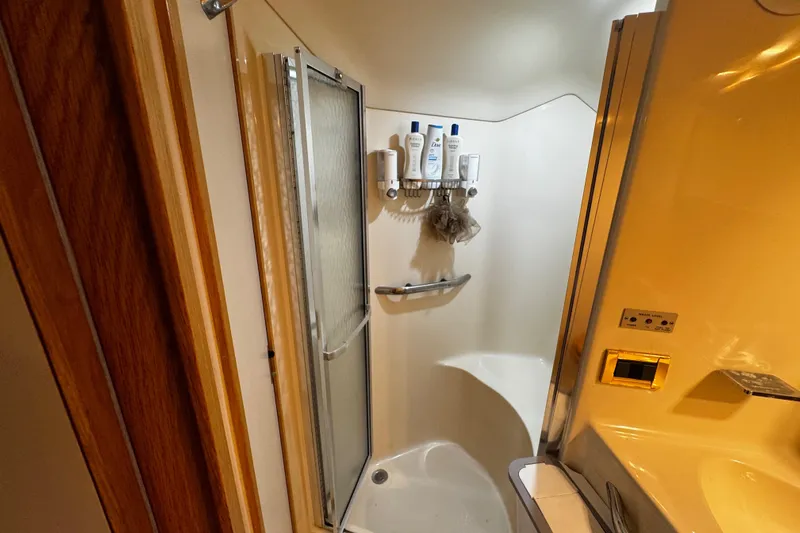  Yacht Photos Pics Bathroom interior of 1999 Sea Ray 440 Express Bridge yacht, featuring shower and toiletries.