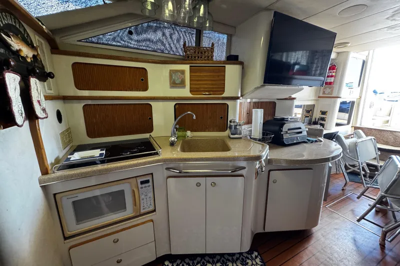  Yacht Photos Pics 1999 Sea Ray 440 Express Bridge kitchen with microwave, sink, and appliances.