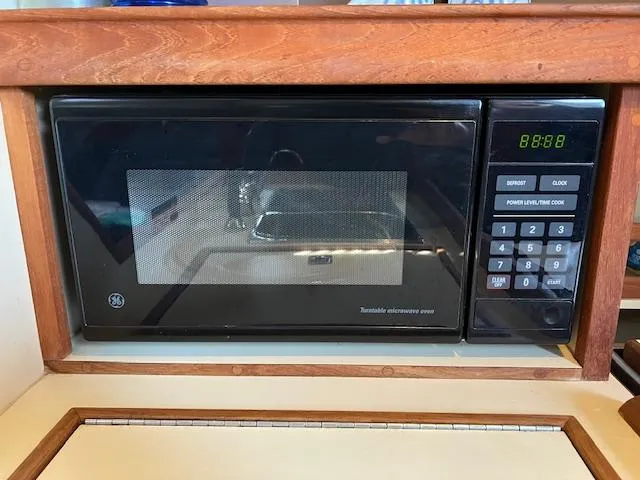  Yacht Photos Pics Built-in microwave in 1999 Island Packet 380 sailboat galley, featuring digital controls and wood trim.